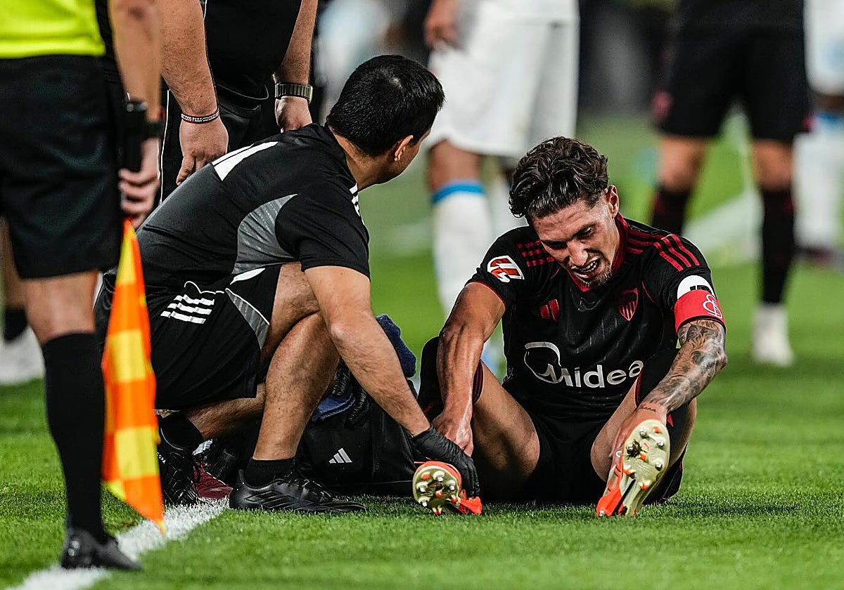 Carmona, con el brazalete de capitán del Sevilla FC, atendido durante el duelo ante el Olympique de Marsella
