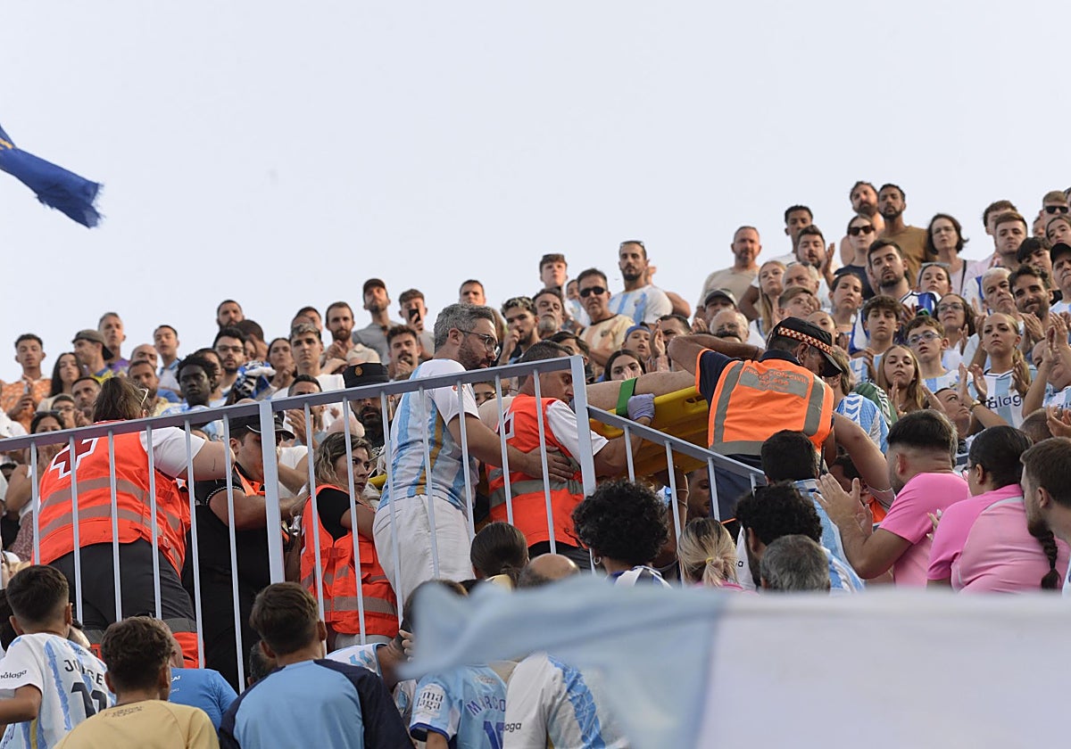 Las asistencias retiran a un aficionado del Málaga durante el partido ante el Betis