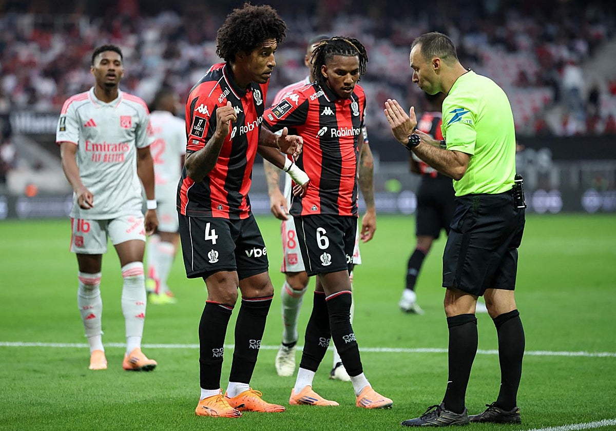 Dante y Boudaoui, jugadores del Niza, hablan con Jerome Brisard, árbitro del partido