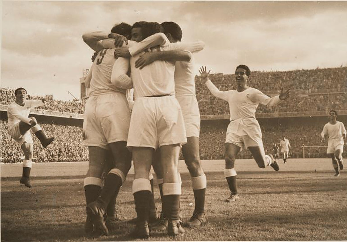 Los jugadores del Real Madrid se abrazan y rodean a Molowny, que acaba de marcar en el clásico del Bernabéu de 1953, en un partido en el que los madridistas se impusieron por un rotundo 5-0. La grada este no tiene construido aún el tercer anfiteatro, en una vetusta estampa de Chamartín