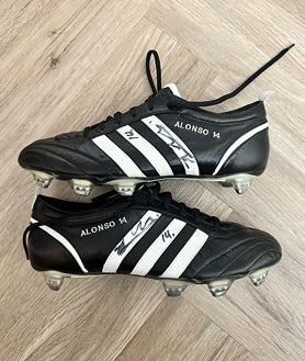 Imagen secundaria 2 - Decoración y recortes en el bar Reds, uno de los principales de los hinchas del Liverpool. A la derecha, las botas de Xabi firmadas