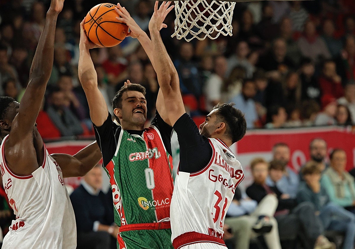 Sergio Cecilia, en un esfuerzo para anotar entre dos defensores de la Cultural y Deportiva Leonesa