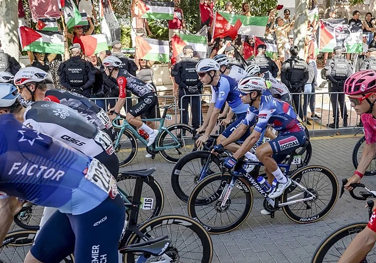 Corredores del equipo Israel Premier-Tech, delante de una manifestación propalestina