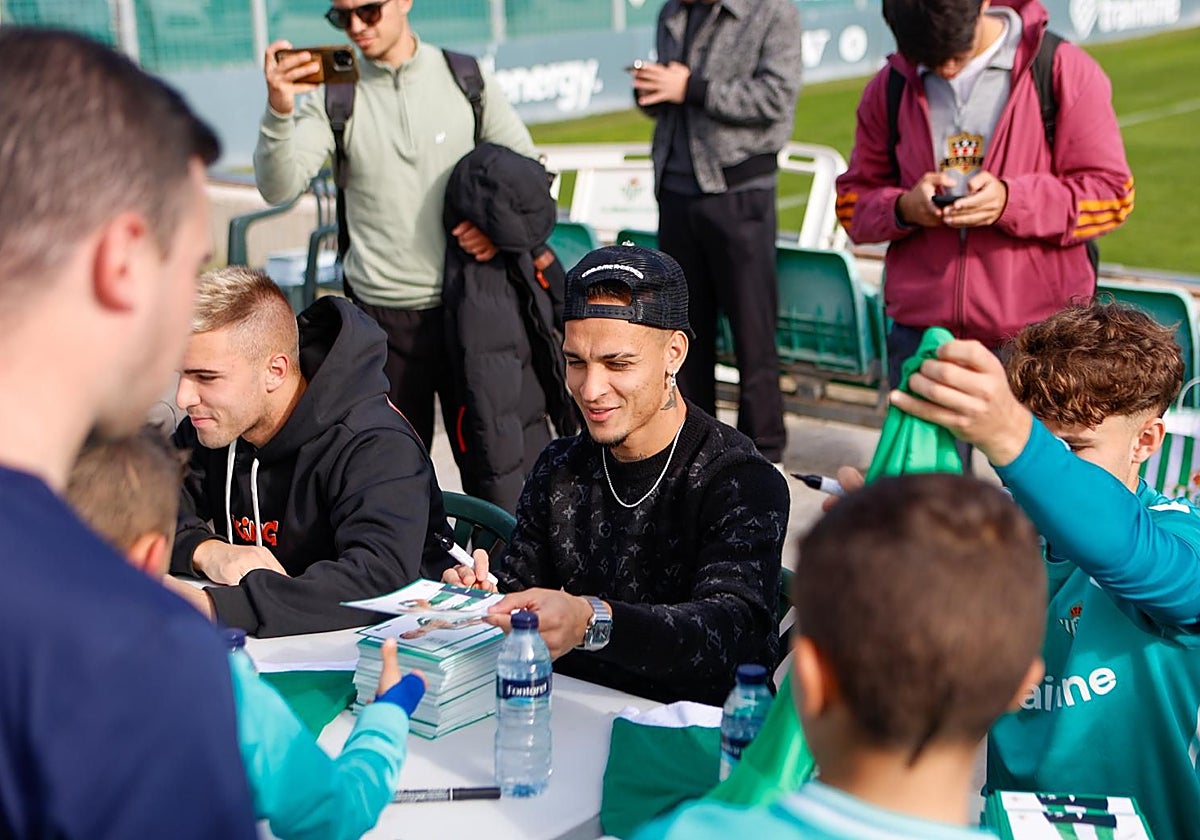 Antony, entre Pablo García y Ángel Ortiz, firma autógrafos a los canteranos béticos