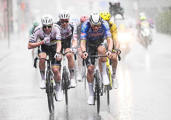 Pogacar y Van der Poel ruedan en paralelo bajo la intensa lluvia.