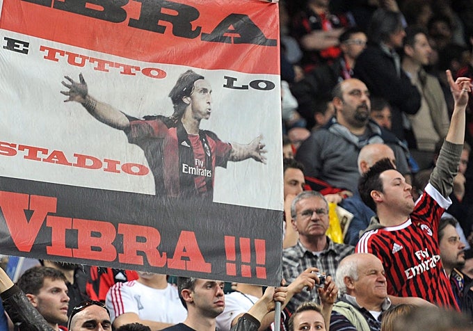 Seguidores del AC Milán animan a su equipo antes del comienzo frente al FC Barcelona en el estadio Giuseppe Meazza de Milán, en 2012.