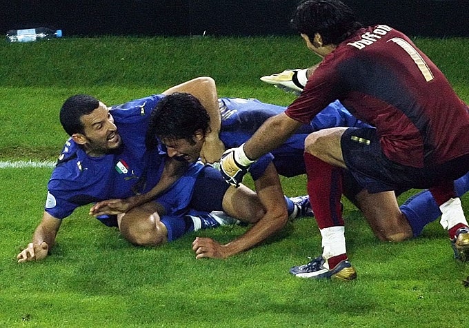 2006: El defensa italiano Fabio Grosso, felicitado por sus compañeros, el también defensa italiano Gianluca Zambrotta, y el portero italiano Gianluigi Buffon, tras marcar el primer gol durante la prórroga del partido de semifinales del Mundial de 2006 entre Alemania e Italia, el 4 de julio de 2006 en el estadio de Dortmund. Italia ganó 2-0 tras la prórroga.