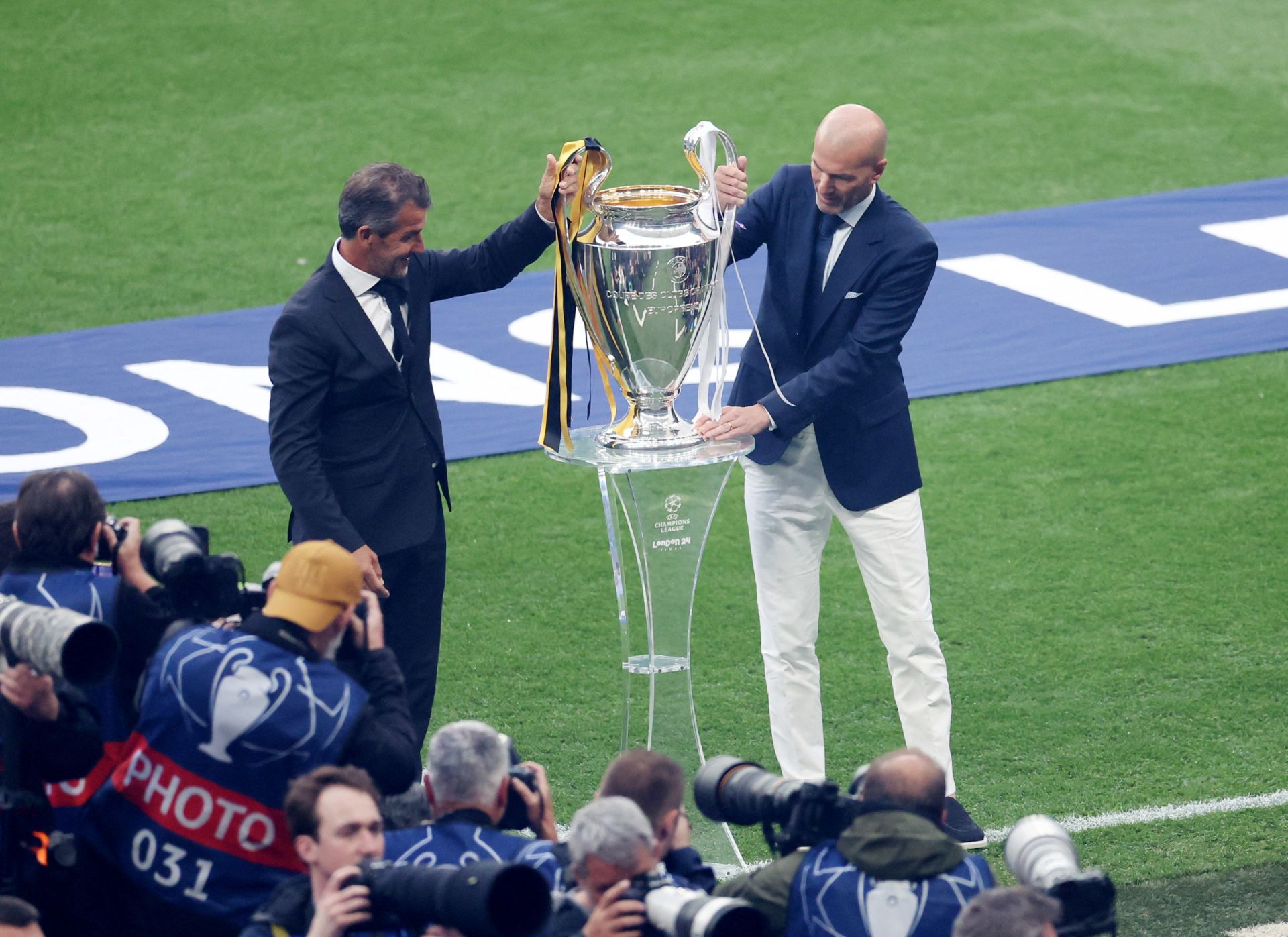 Karl-Heinz Riedle y Zinedine Zidane junto al trofeo de campeón de la Champions League