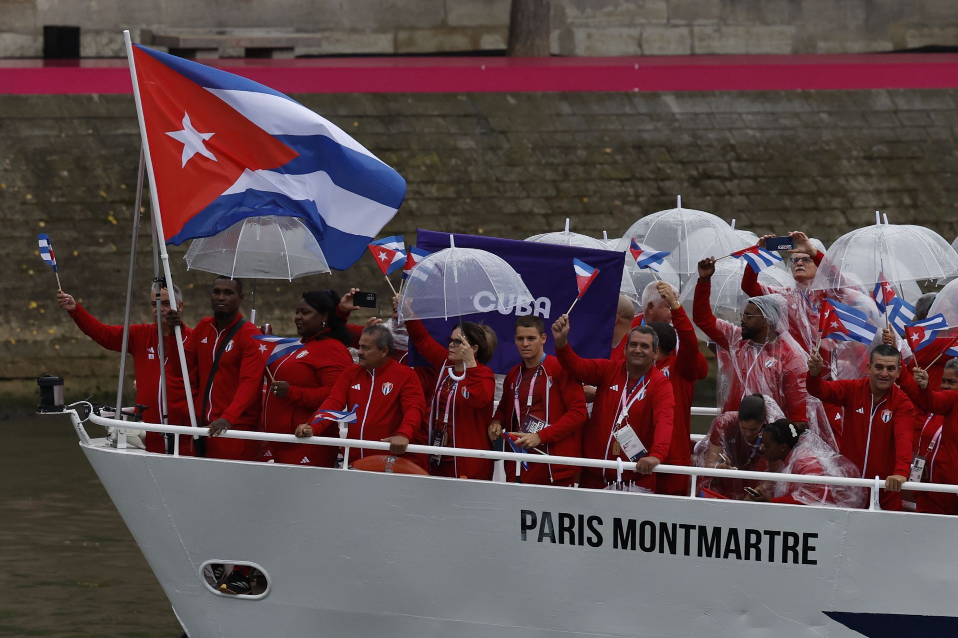 Los deportistas cubanos levantan sus banderas en el barco Paris Montmartre