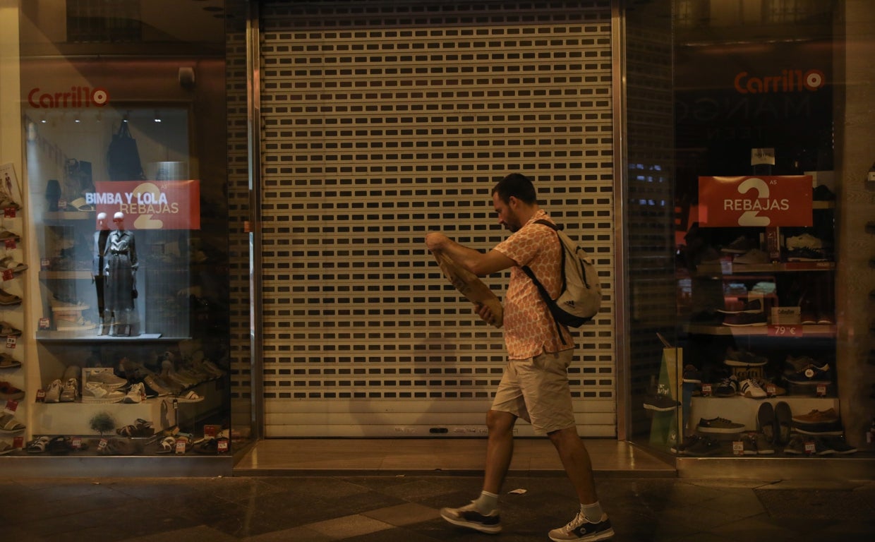 Una dependienta de un comercio, activando el aparato de aire acondicionado