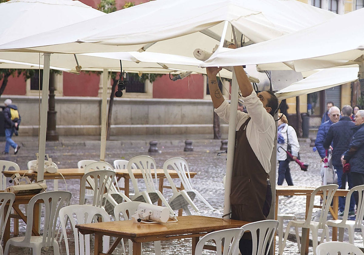 Un hostelero encendiendo la estufa en la terraza, en Andalucía