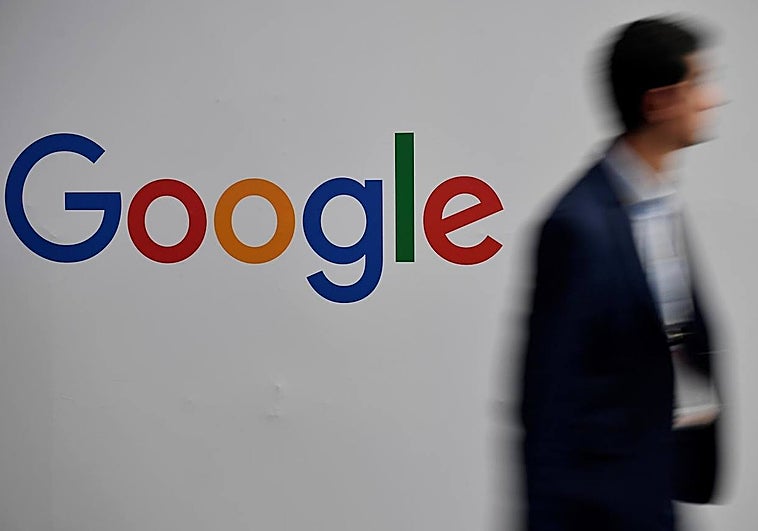 Vista de un hombre que pasa frente al logo de Google, en una fotografía de archivo