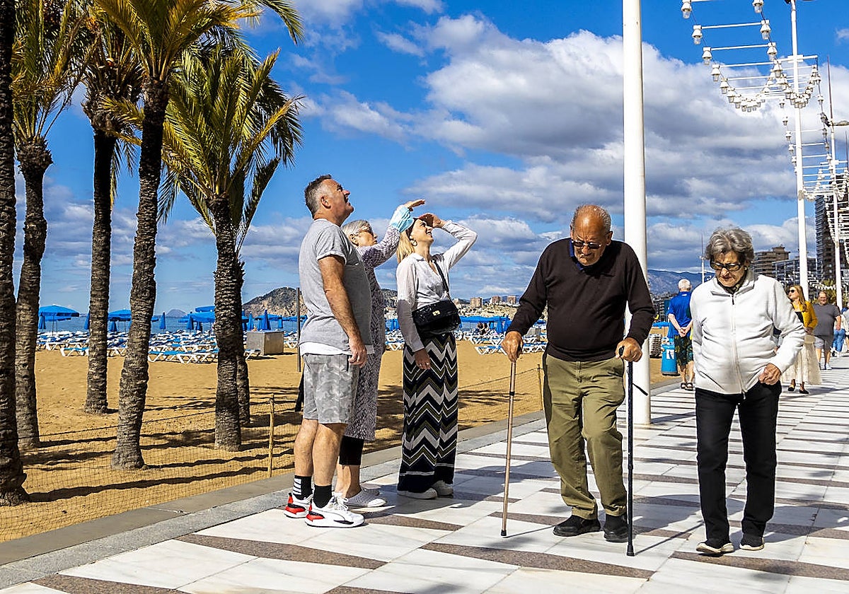Dos turistas pasean por la playa de Levante de Benidorm