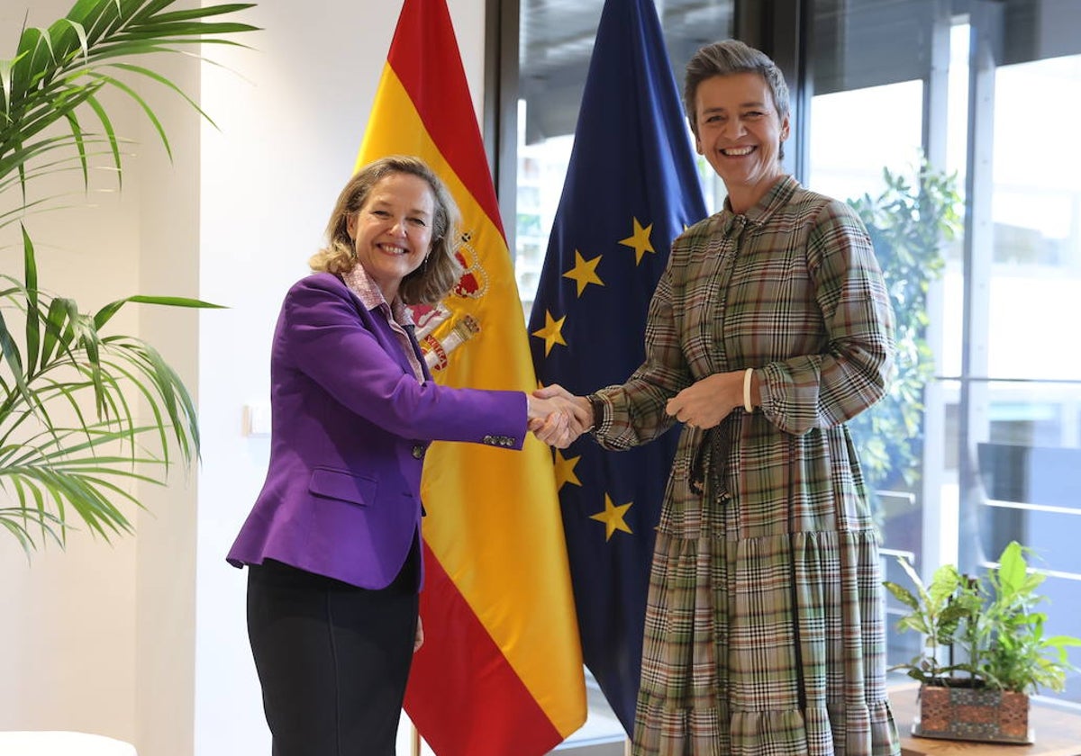 Nadia Calviño (izq.) estrecha la mano a Margrethe Vestager