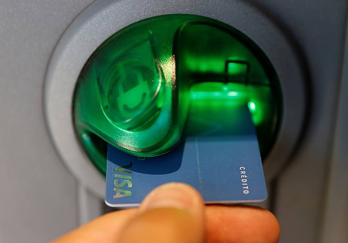 Un usuario introduce su tarjeta en un cajero