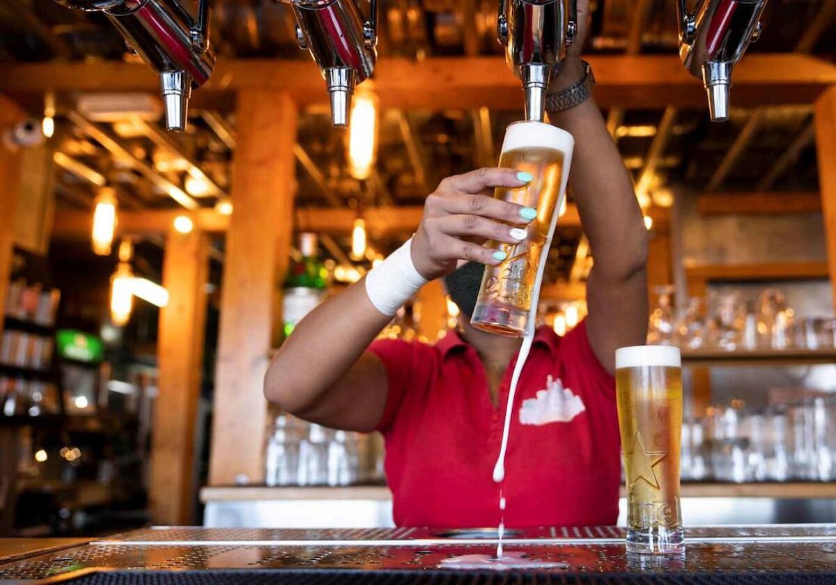 Una camarera sirve una cerveza en un bar