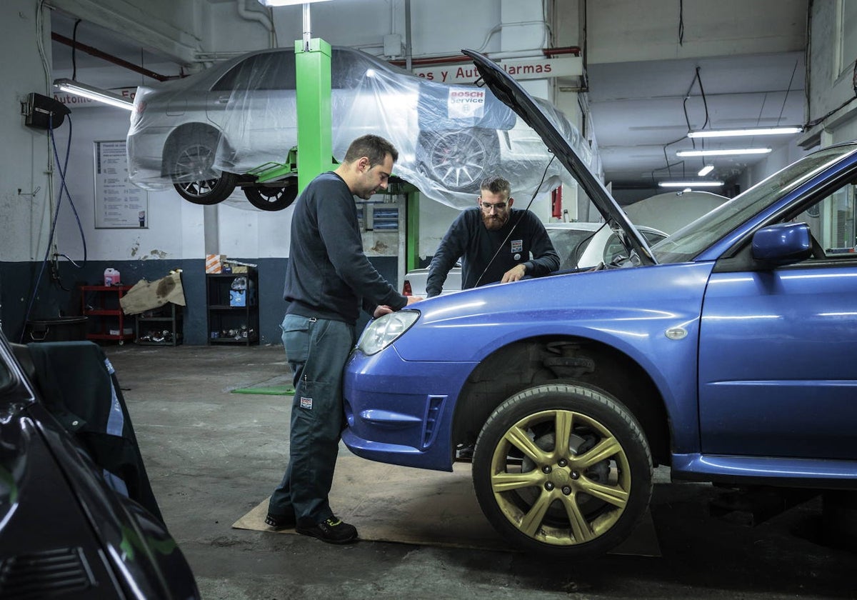 Dos mecánicos arreglando un coche en un taller de Valencia