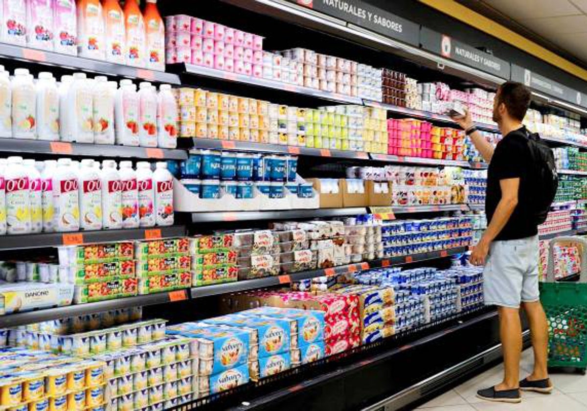 Un joven mira el lineal de un supermercado