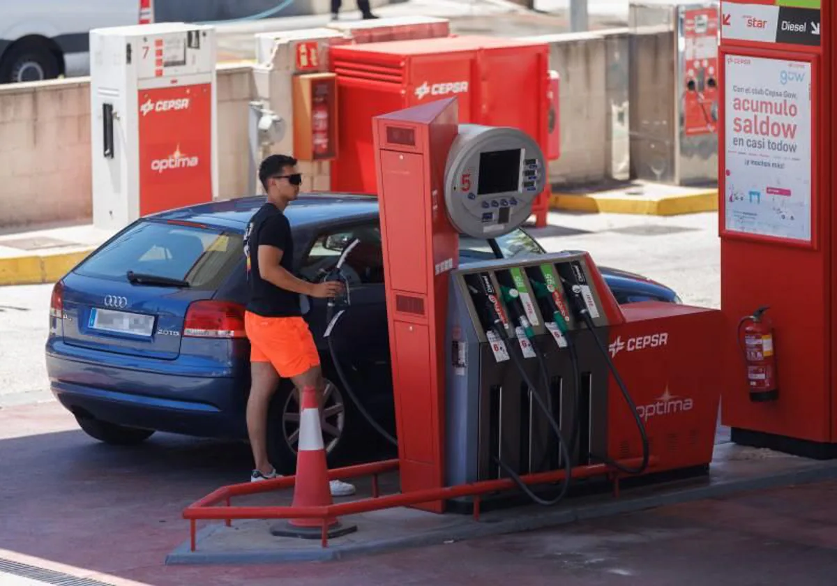 A user fills up the tank at a gas station