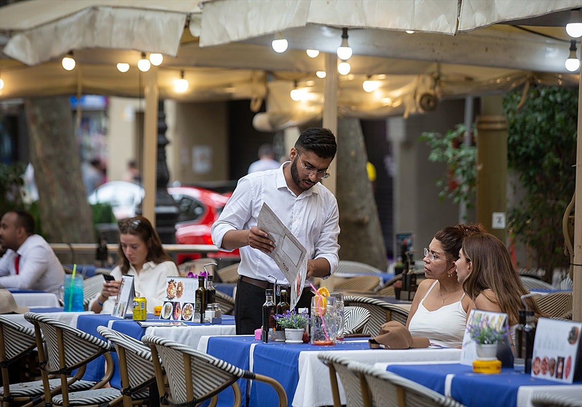 Un camarero atiende a una mesa en las Ramblas