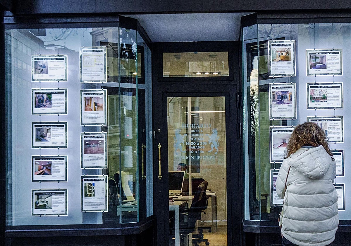Una mujer frente al escaparate de una inmobiliaria en Madrid