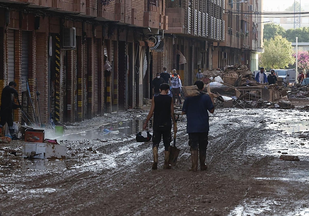Voluntarios colaboran durante las labores de limpieza en una calle en Catarroja (Valencia)