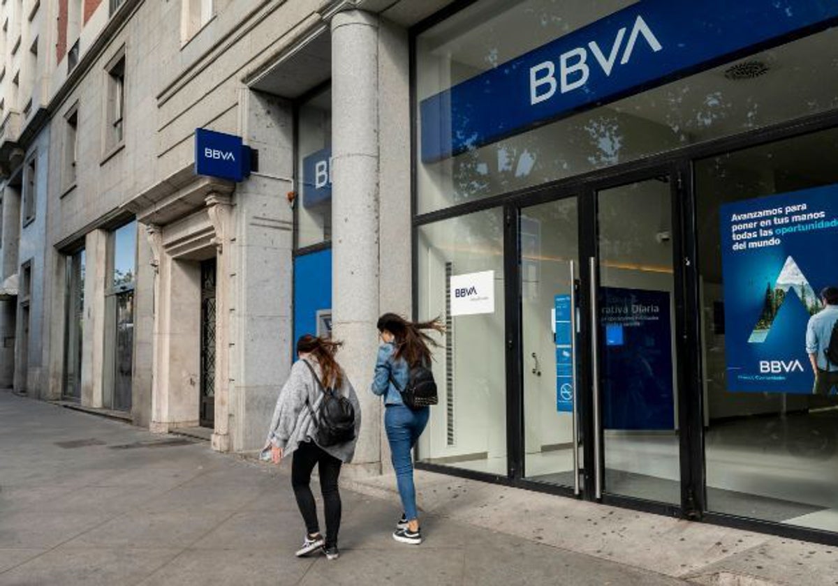 Dos personas pasan frente a una sucursal bancaria