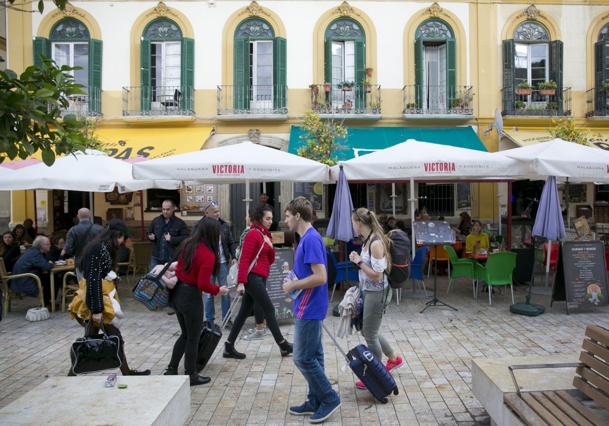 Varios turistas pasean por la Plaza de la Merced en Málaga