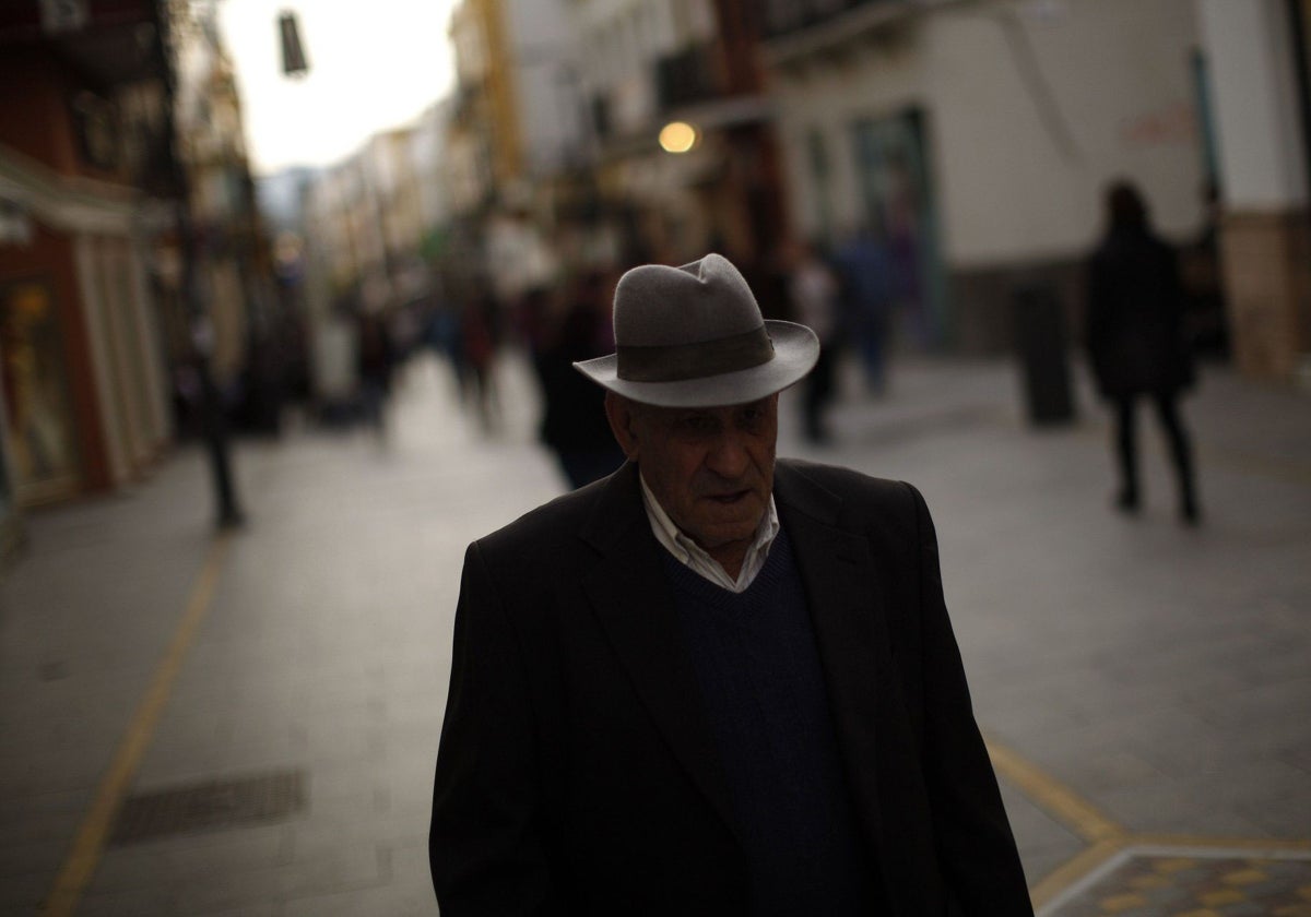 Un jubilado paseando por una calle.