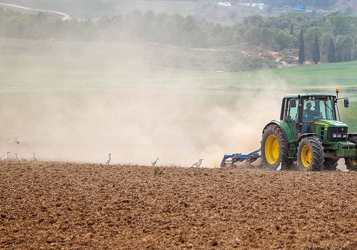 Un agricultor labra con tractor la tierra
