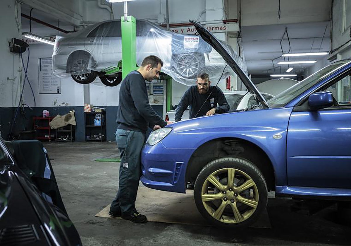 Dos trabajadores en un taller de reparación de coches