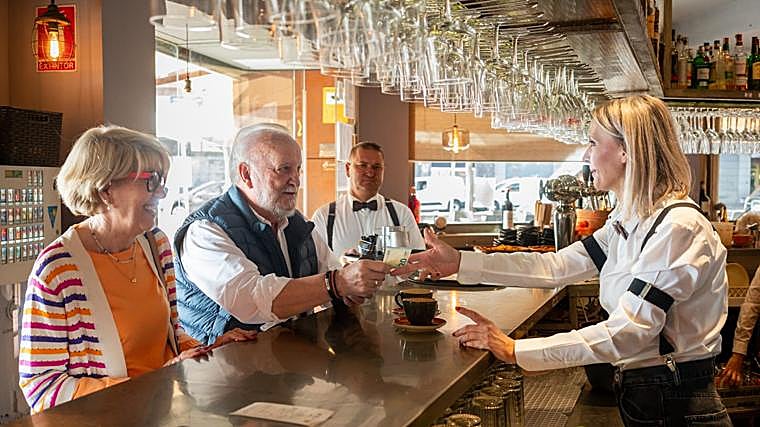 Mª Carmen y Benito, pagando el desayuno en un bar