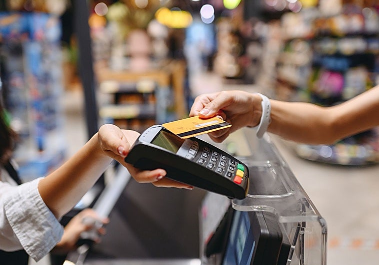 Una mujer abona una compra con tarjeta en un comercio.