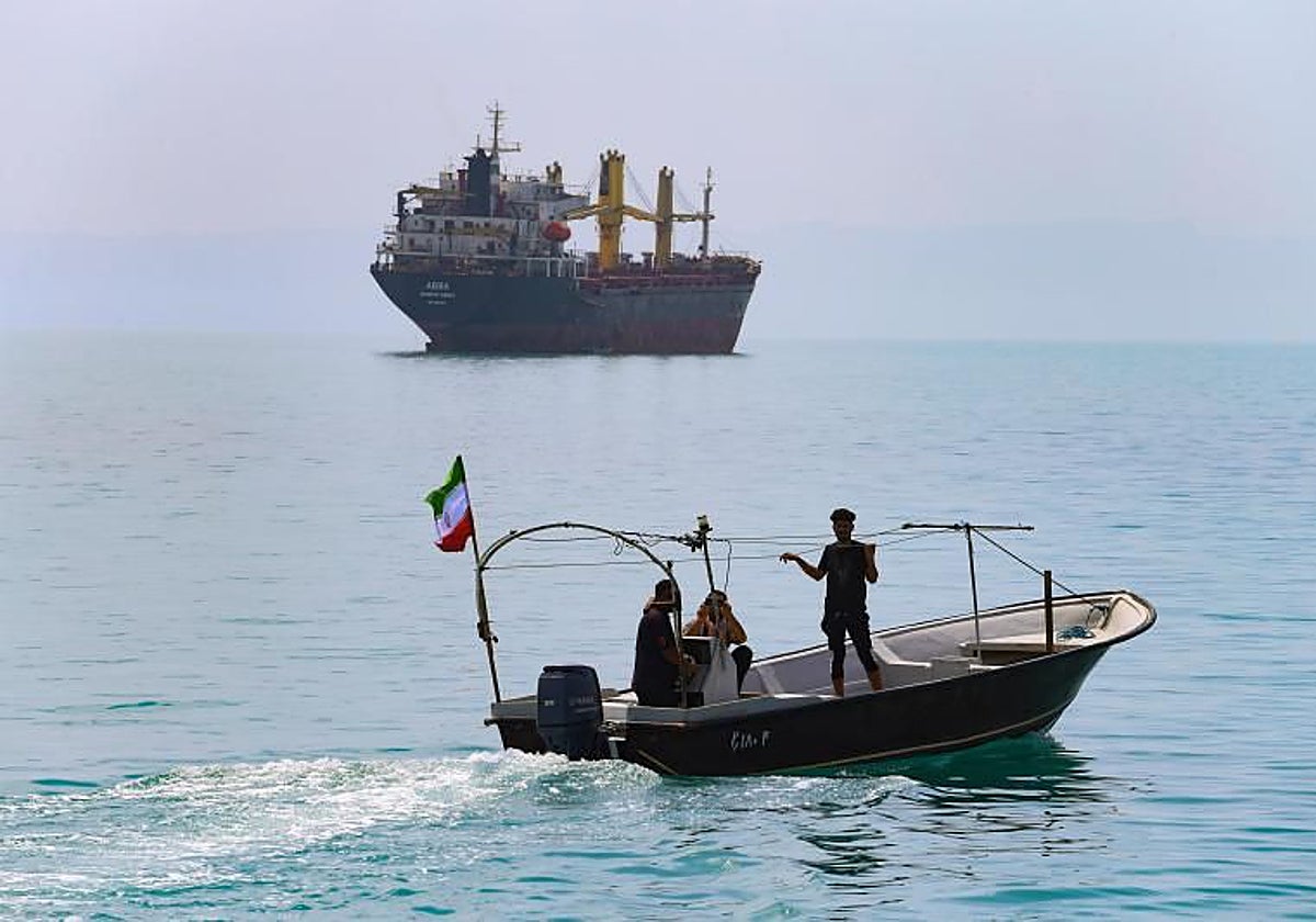 Un petrolero atraviesa el estrecho de Ormuz ante la observación de una lancha iraní.