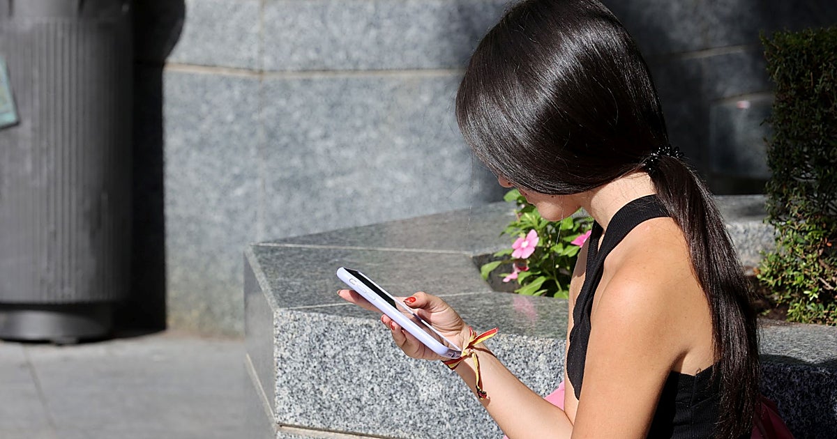 Person at airport using smartphone with eSIM connectivity abroad