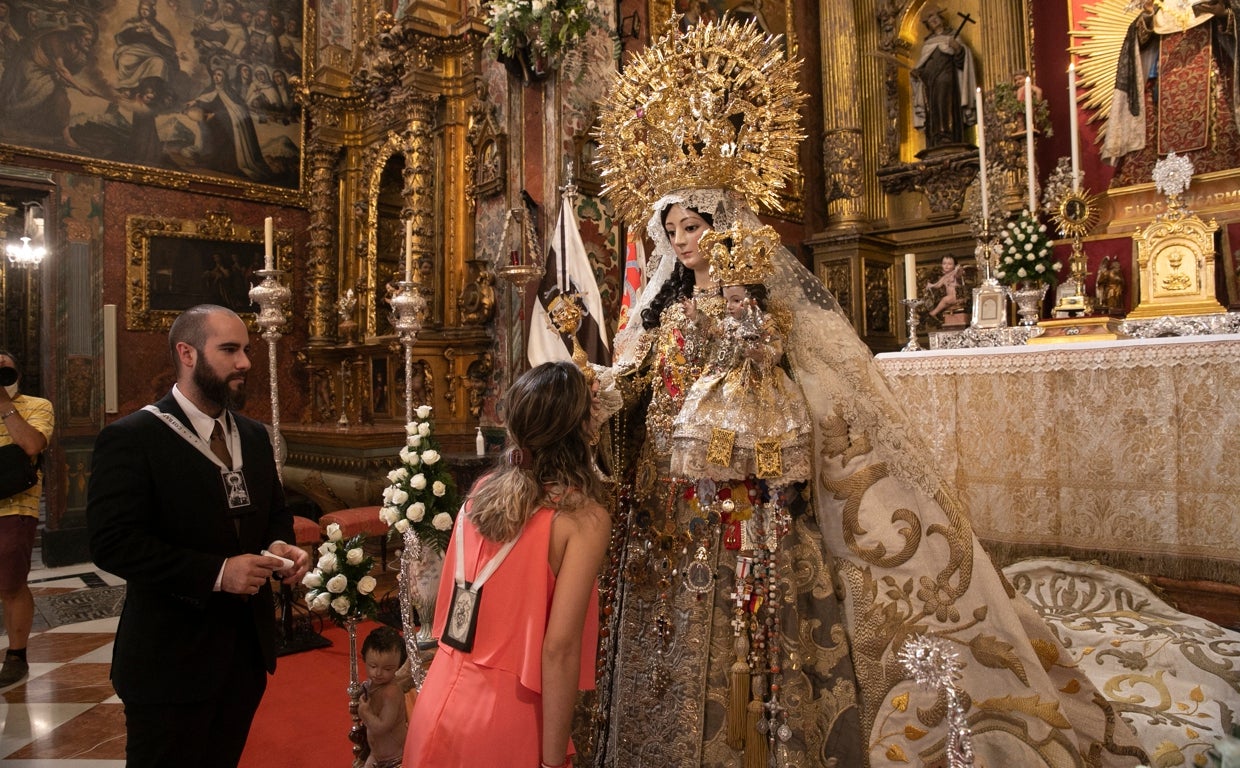 Una hermana del Carmen besa la mano derecha de la Virgen