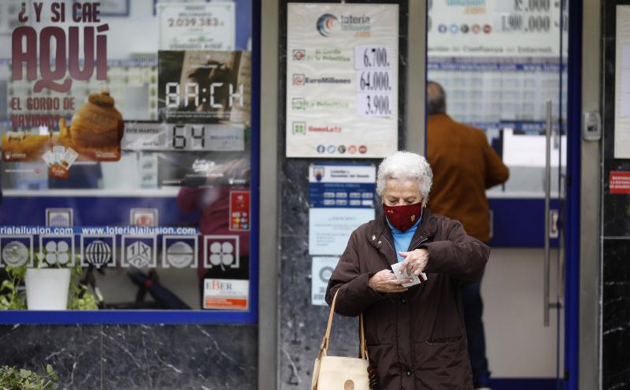Una mujer sale de una administración de Lotería