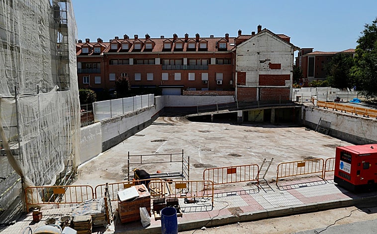 Imagen principal - El solar del edificio demolido, cubierto por cemento; pancartas pidiendo soluciones, y grietas en algunos de los edificios