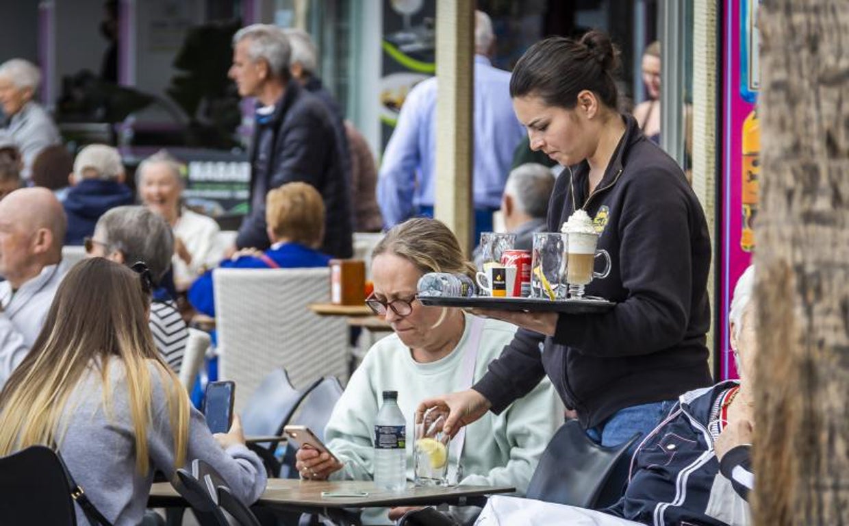 Imagen de archivo de una camarera sirviendo a unos clientes en una terraza de Benidorm