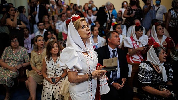Una chulapa contempla la imagen de La Paloma durante el descenso del cuadro