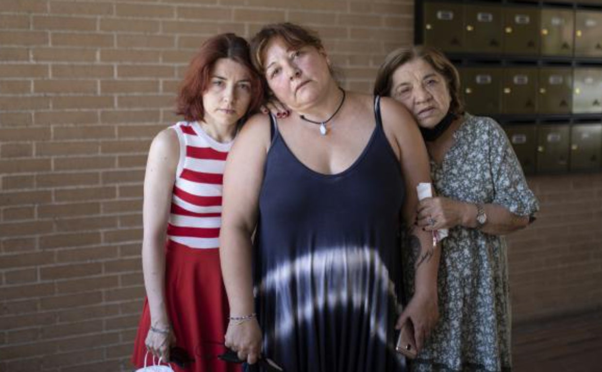 Nines Triano, entre su hermana y su madre, en el portal de su vivienda