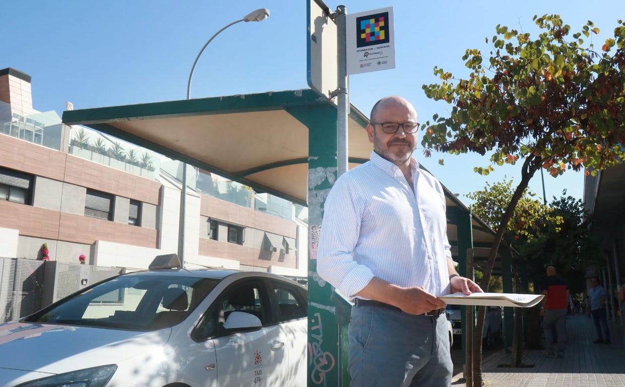 Bernardo Jordano posa en la parada de taxis del centro de salud Carlos Castilla del Pino junto a uno de los códigos QR de la aplicación