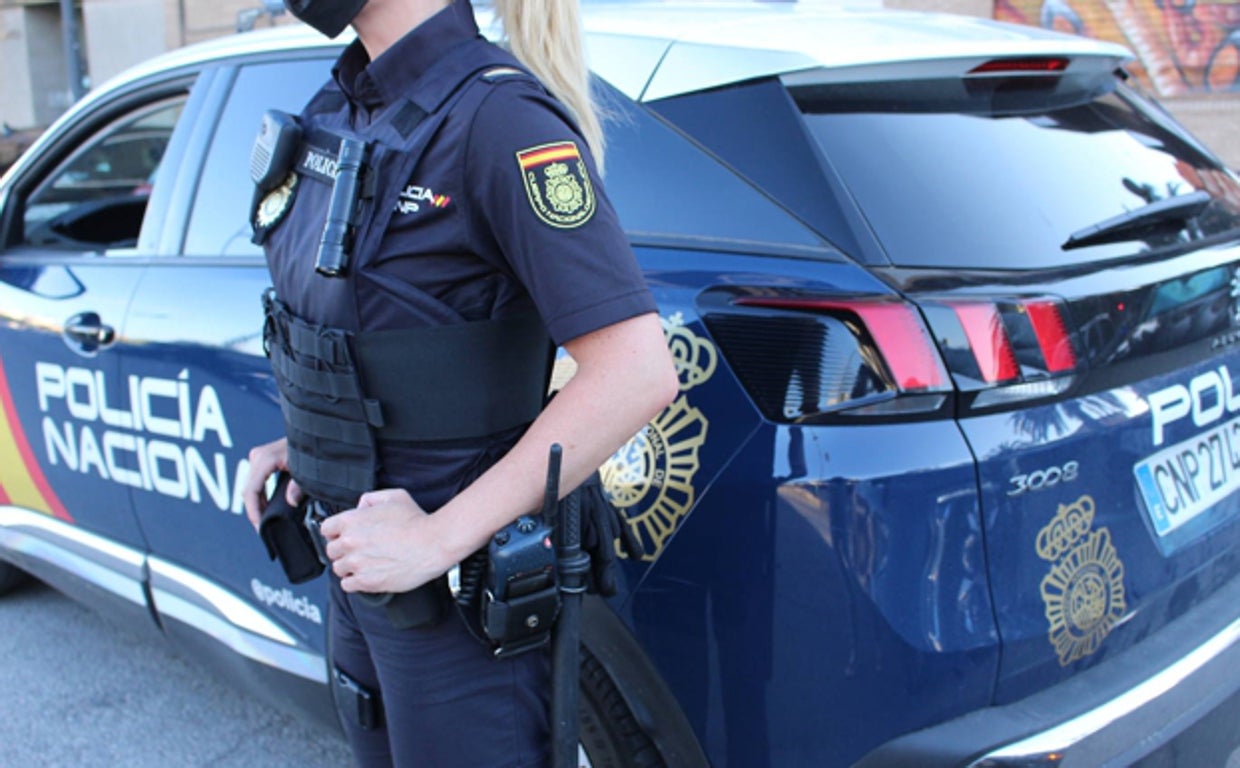 Agente y coche patrulla de la Policía Nacional