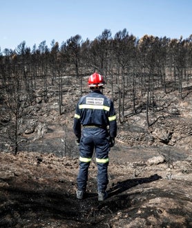 Imagen secundaria 2 - Arriba, José David inspecciona los restos del camión calcinado. Abajo, Andrés posa con el uniforme ante un paisaje desolador 