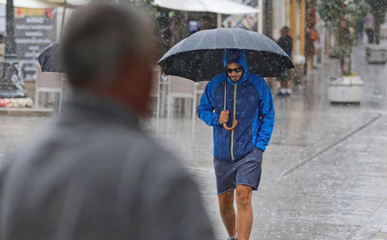 Imagen de archivo de un hombre paseando por Valencia en un día lluvioso