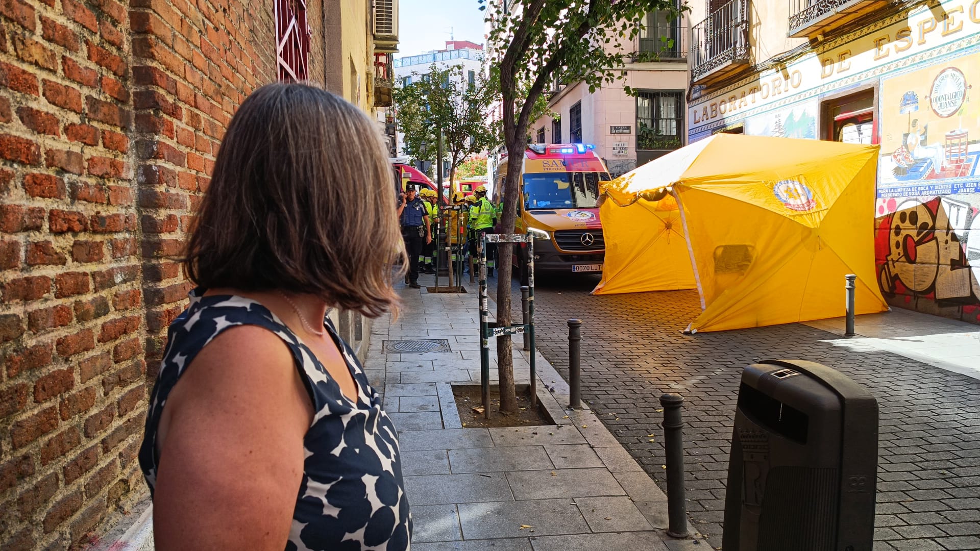 Una de las vecinas contempla cómo ha quedado la calle, donde se ha establecido una tienda de campaña para atender a posibles heridos.