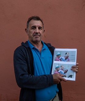 Imagen secundaria 2 - Sobre estas líneas, el enrejado con los recuerdos de algunas de las víctimas del descarrilamiento. Una vecina señala la imagen de una niña que falleció, junto a su madre, en las vías. Al lado, Evaristo, el primero en bajar al tren y socorrer al maquinista de la cabina, con una fotografía del momento