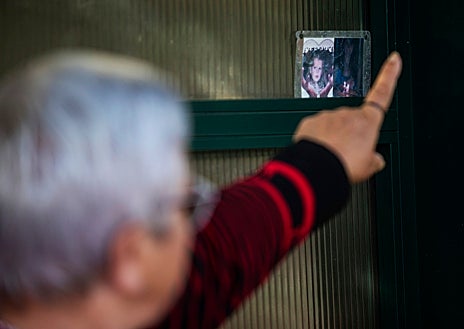 Imagen secundaria 1 - Sobre estas líneas, el enrejado con los recuerdos de algunas de las víctimas del descarrilamiento. Una vecina señala la imagen de una niña que falleció, junto a su madre, en las vías. Al lado, Evaristo, el primero en bajar al tren y socorrer al maquinista de la cabina, con una fotografía del momento