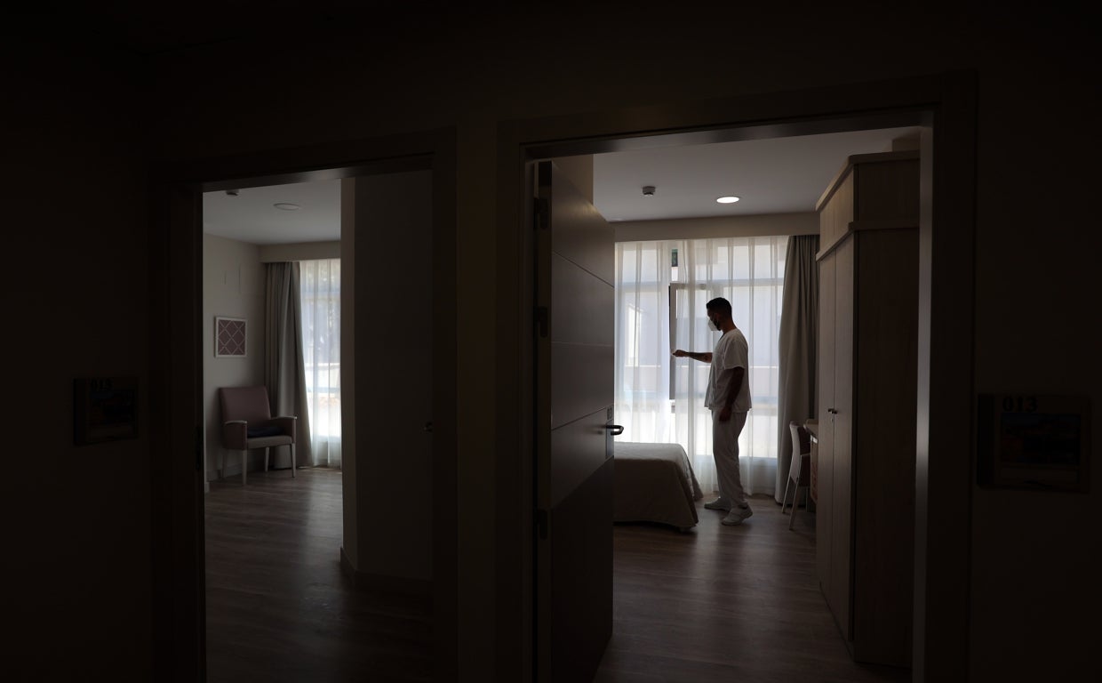 Un auxiliar pone a punto una habitación de una residencia privada