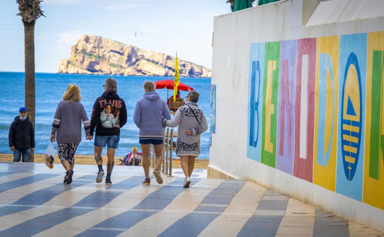 Turistas en Benidorm, con la isla al fondo